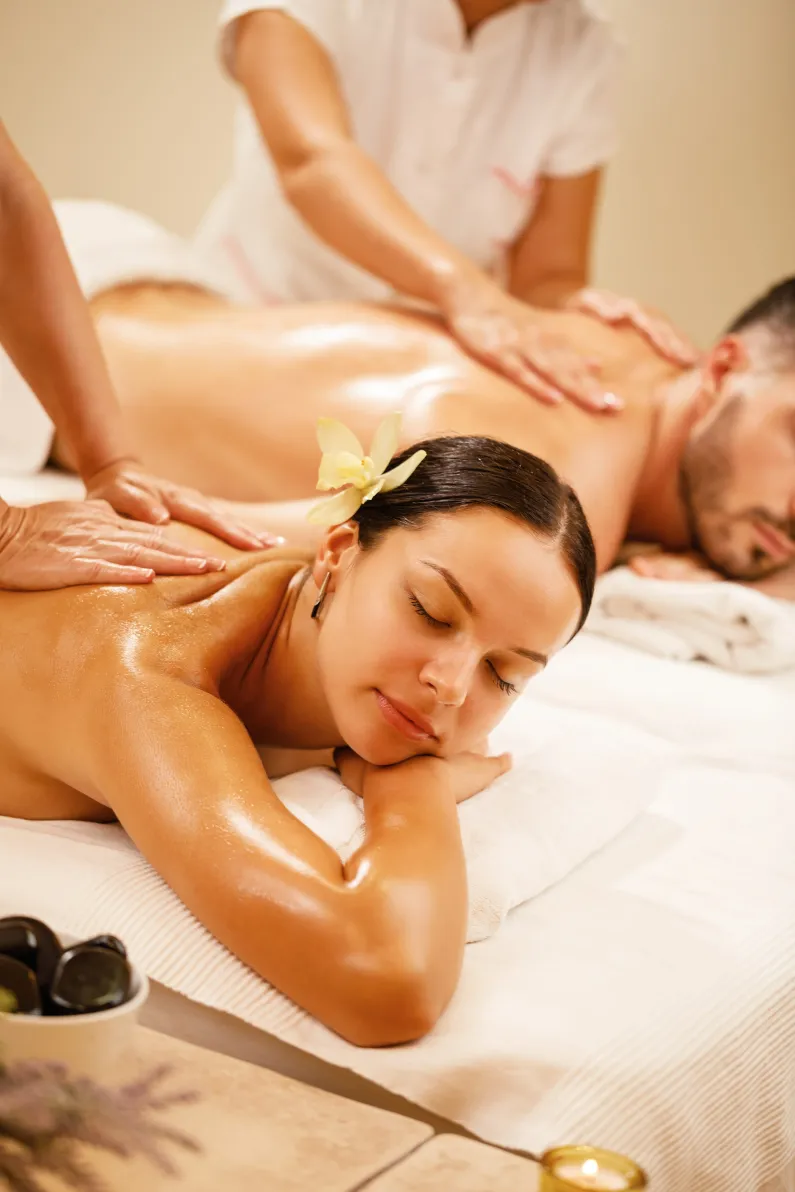 Couples massage side by side in a peaceful studio