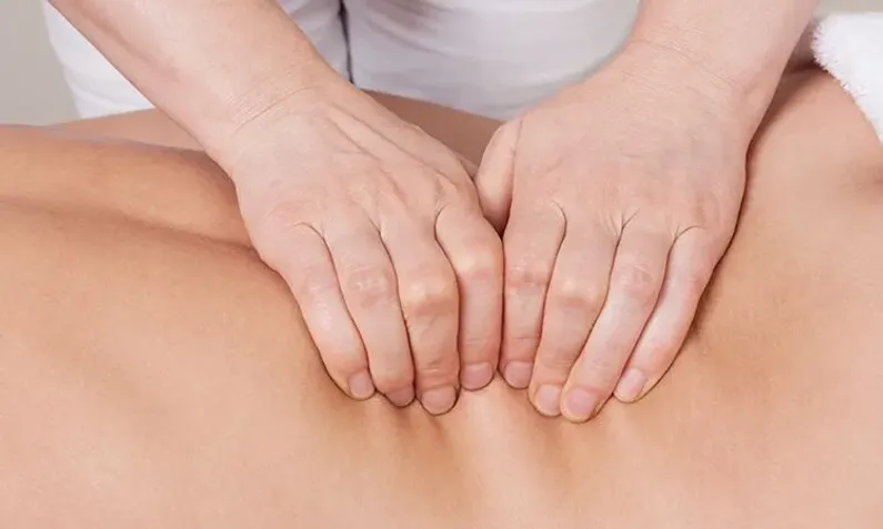 Deep tissue massage therapist working on client's back